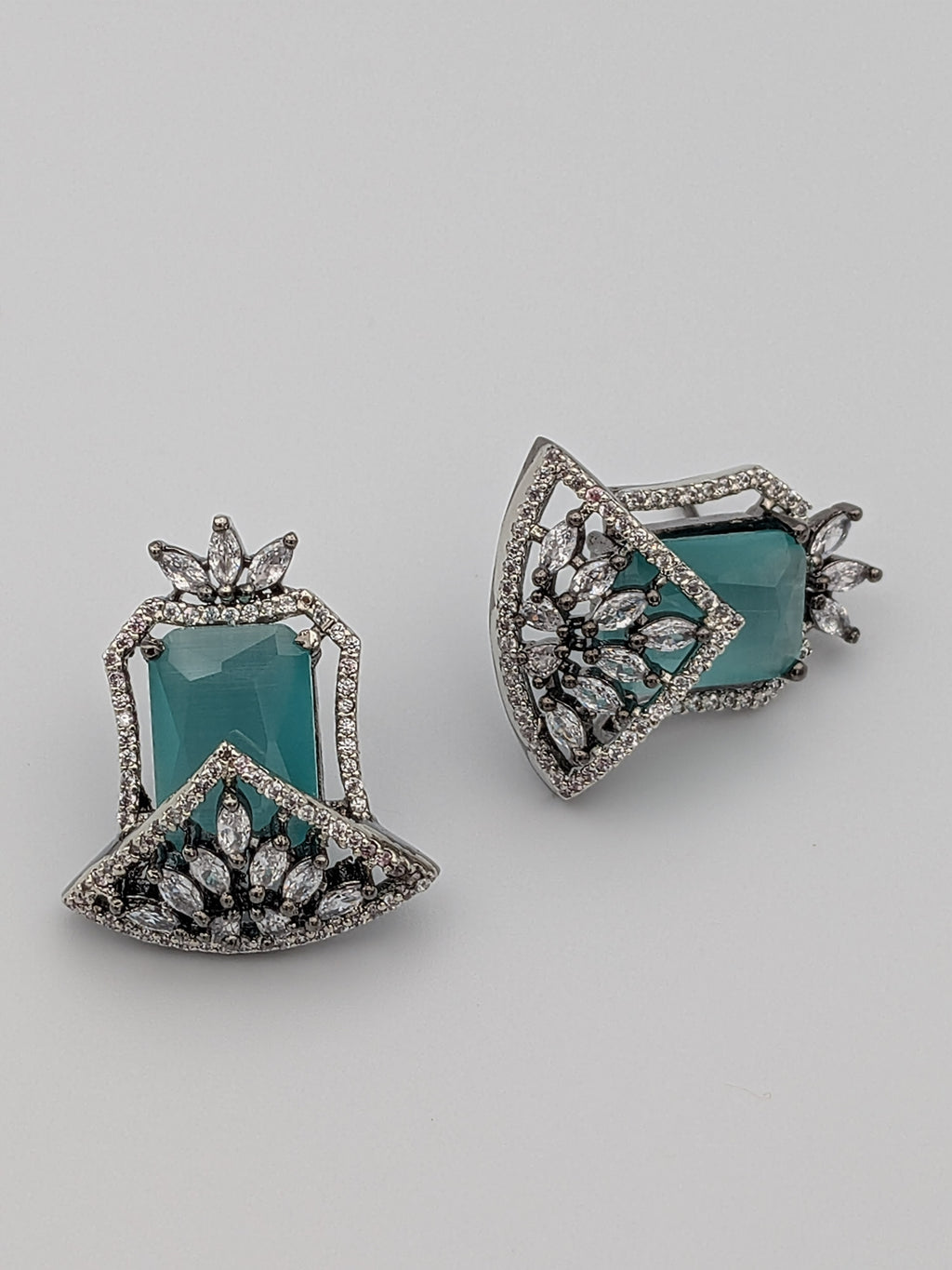 Aqua-blue statement stud earrings with rhodium finish, marquise-cut zircon clusters, and geometric design