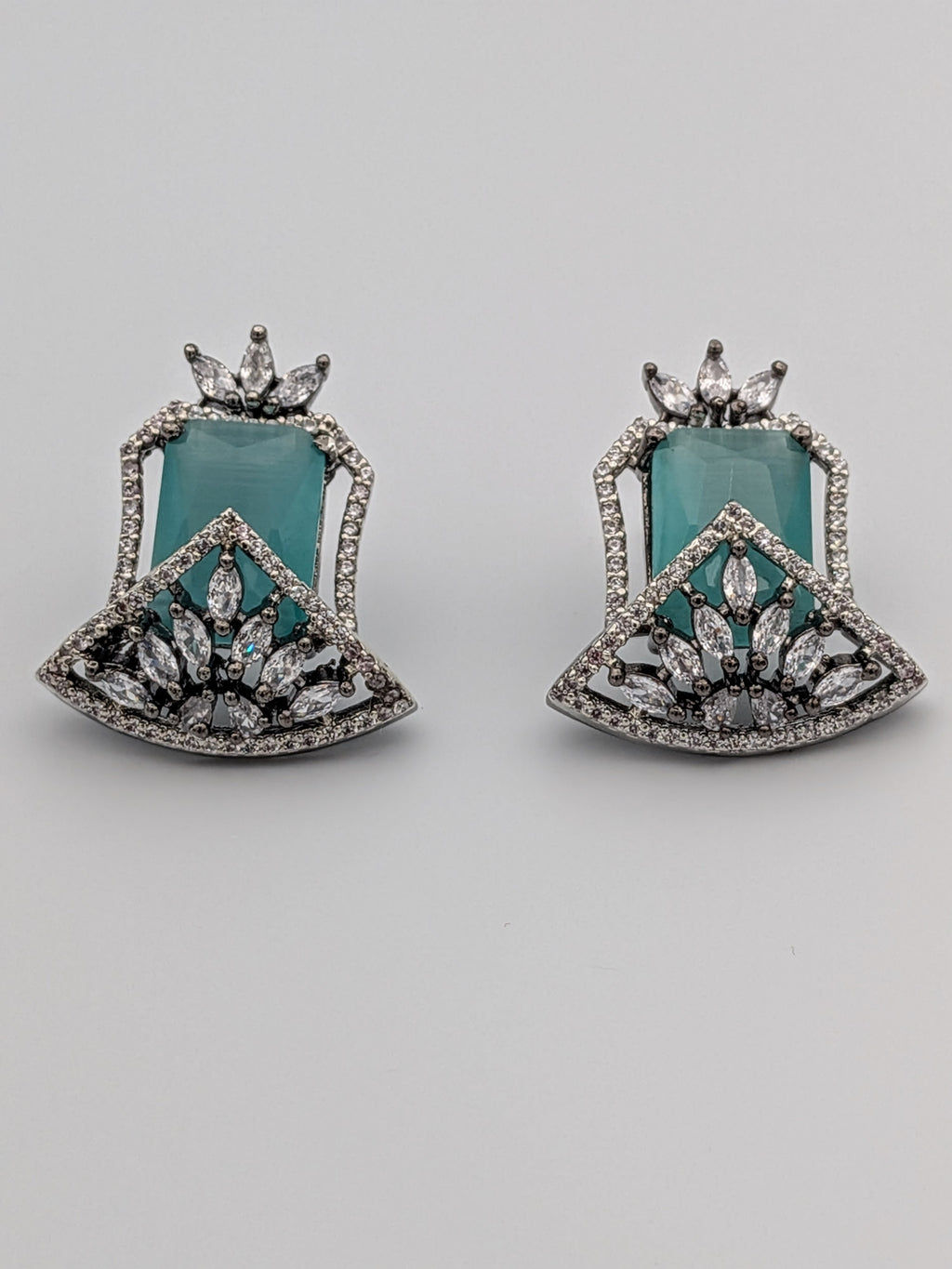 Aqua-blue statement stud earrings with rhodium finish, marquise-cut zircon clusters, and geometric design