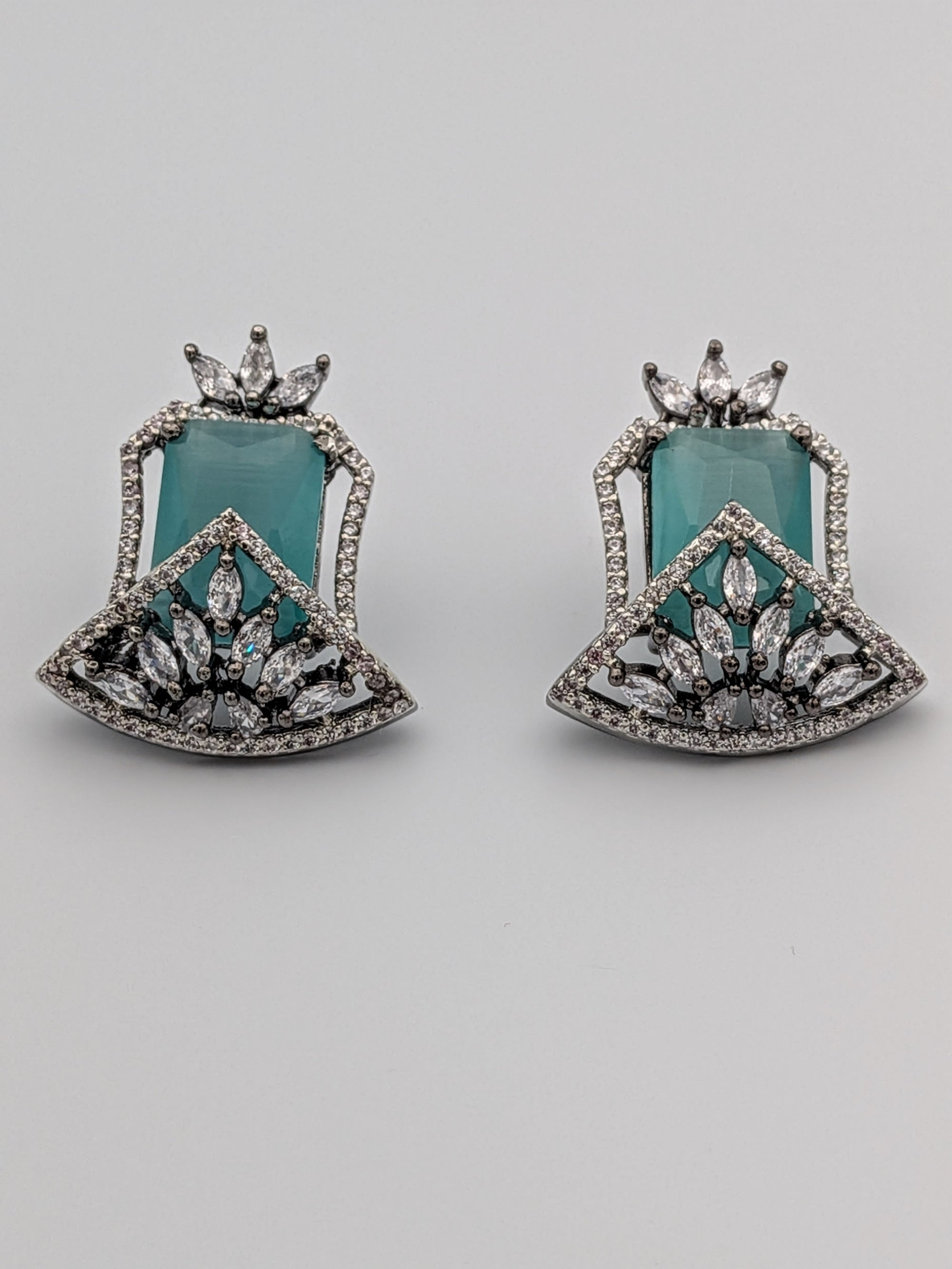 Aqua-blue statement stud earrings with rhodium finish, marquise-cut zircon clusters, and geometric design