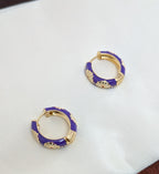 Viola Bloom Huggie Hoops – violet enamel hoops with white daisy and gold details