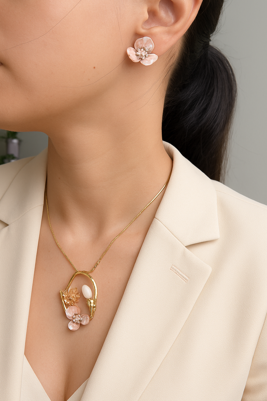 Close-up wearing a gold necklace and pink floral earrings